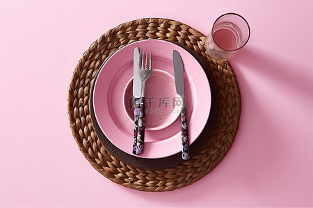 粉红色墙壁上显示的餐垫上有盘子