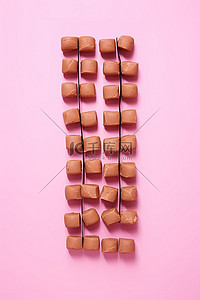 巧克力坚果背景图片_粉红色背景中的巧克力核桃