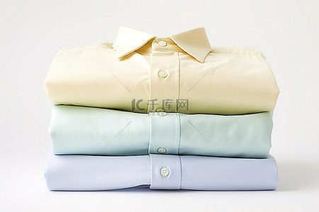 三件衬衫以不同颜色折叠在白色表面上