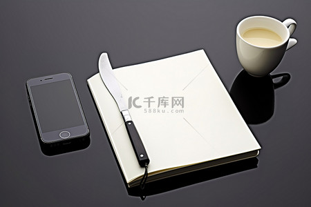 笔记本和叉子旁边的手机