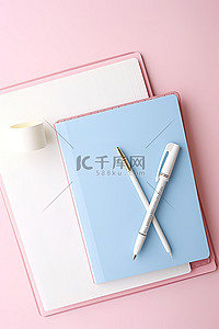 包含纸和笔的粉色和蓝色笔记本