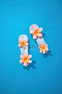 蓝色水仙花背景图片_漂浮在水中的小花作为人字拖，配有粉红色人字拖脚蹼和水仙花花