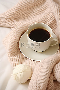 毯子背景图片_一杯带手套的咖啡，上面铺着柔软的毛毯