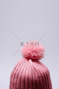 顶部有毛绒球的粉色针织帽
