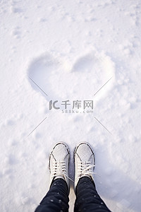 坐地上背景图片_人类坐在雪地上，面前是雪中绘制的心形