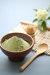 抹茶粉背景图片_这小碗绿茶粉和一个木搅拌器放在桌子上