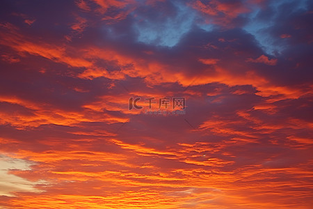 傍晚天空背景背景图片_橙色的傍晚天空，高高的云彩和天空中的火焰