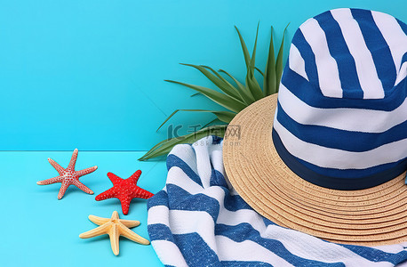 蓝色帽子帽子背景图片_蓝色背景上的帽子毛巾旗子和海星