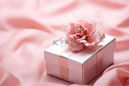 粉色絲綢背景图片_照片：一个小礼品盒，在粉红色的布上绑着粉红色的丝带