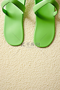 白色表面上的绿色拖鞋
