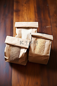 三袋不同谷物都装在木桌上的棕色纸袋里