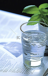 英文报纸背景图片_一杯水和植物在报纸上的纸上