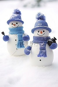 两个戴着蓝色帽子的雪人
