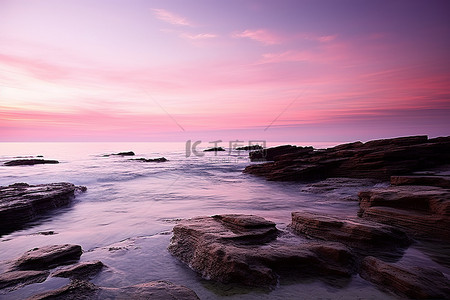 半岛背景背景图片_海洋有粉红色的天空，在岩石上形成紫色的天空
