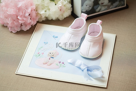 婴儿鞋背景图片_相册旁边有一张照片和一双婴儿鞋