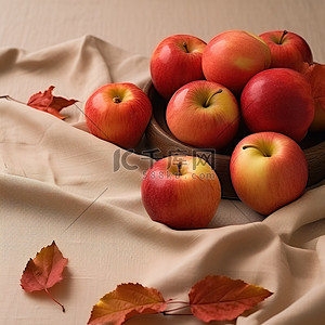 苹果叶子背景图片_苹果放在布桌上，旁边有叶子