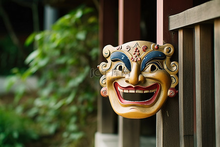 木屋旁的栅栏上有一个亚洲小面具