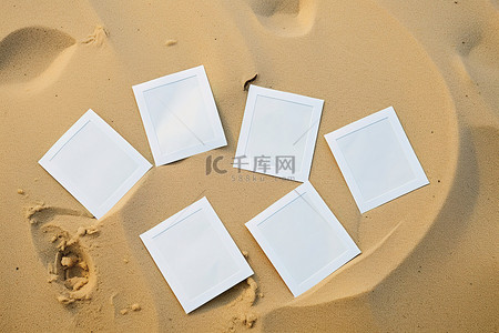 四张白色贴纸铺在沙子上