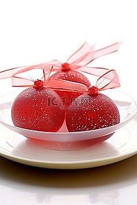 红色盘子背景图片_两个釉面红色玻璃装饰品放在盘子上
