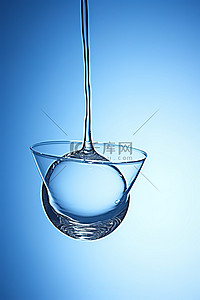 漂浮在蓝色环境中的玻璃杯中的一滴水