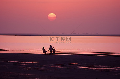 女子成人礼背景图片_日落时分，四个孩子正在靠近太阳的海滩上散步