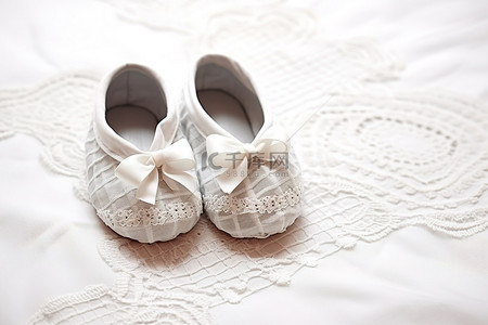 婴儿鞋背景图片_一双婴儿鞋，旁边是带有白线的白色桌布