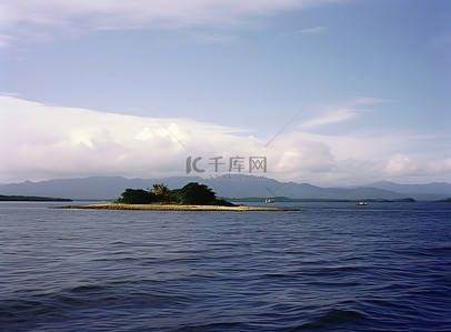 有有背景图片_开阔水域中的一座小岛，远处有山