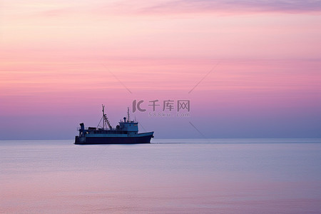 一艘船在海上驶过夕阳