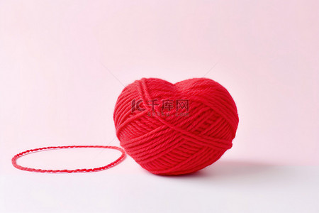 红色针织背景图片_粉红心形上的红色毛线球
