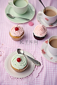 一杯茶纸杯蛋糕和放在桌布上的盘子