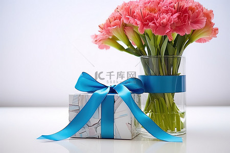 礼物丝带礼物背景图片_一瓶鲜花放在蓝色和粉色丝带礼物旁边