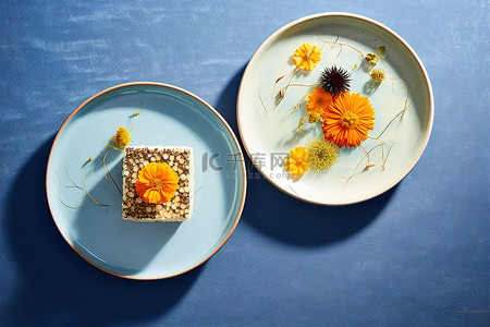 蓝食品背景图片_两个盘子放在白色桌子上的蓝色表面上