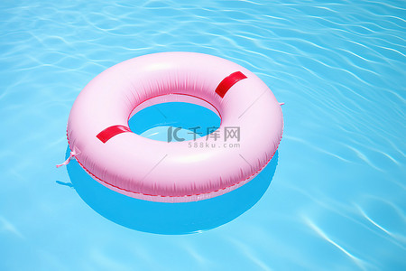 漂浮在蓝色游泳池中的红色圆环