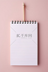 文具笔记本背景图片_白色背景上有铅笔的纸质文具笔记本