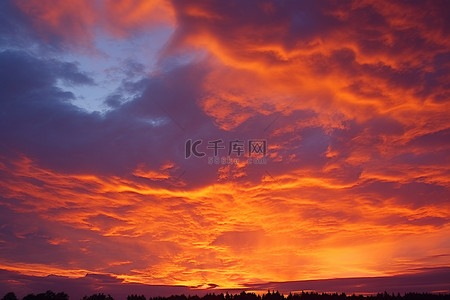 傍晚天空背景背景图片_橙色的傍晚天空，高高的云彩和天空中的火焰