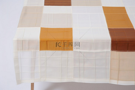 缝背景图片_带有分层白色方块和棕色块的绗缝桌布