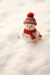 圣诞节雪地礼物背景图片_坐在雪地里的小雪人