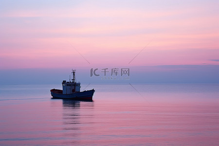 一艘小船漂浮在海洋中，夕阳红红