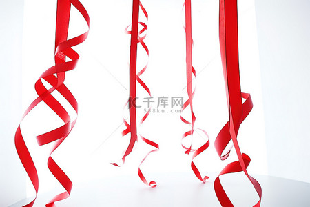 圣诞节挂背景图片_天花板上挂着两条红色卷曲丝带
