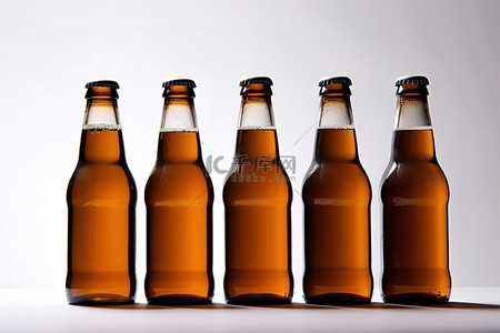 啤酒白背景图片_白色表面上的五个棕色啤酒瓶