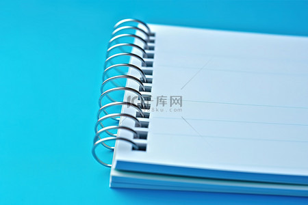 备忘录背景图片_白色笔记本在蓝色表面上用螺丝打开