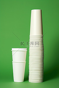 绿色背景中，一个白色杯子站在一个绿色杯子旁边