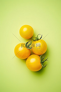 食品背景黄色背景图片_浅绿色背景中的三个黄色西红柿