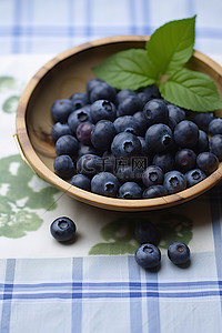 蓝莓奶酪背景图片_花桌布上的一碗蓝莓木碗