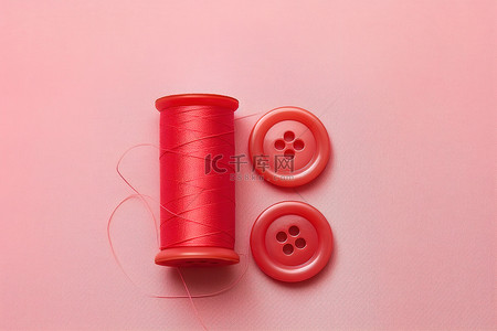 纽扣小铺背景图片_红色缝纫线和粉色织物上的纽扣的顶视图