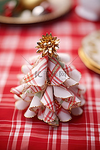 格子背景布背景图片_一块折叠的圣诞织物树，放在红白格子布上