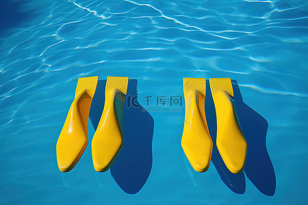 两双黄色脚漂浮在蓝色游泳池水中