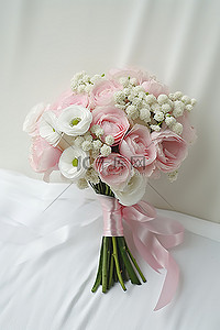一小束白色和粉色的花朵用白色丝带绑在一起