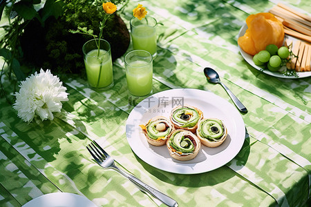 一张野餐桌，上面有各种各样的蔬菜盘子叉子和刀