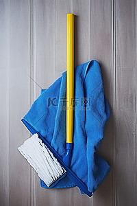 工具手柄背景图片_一个空的拖把手柄，上面有一块蓝色的布和一块黄色的拖把